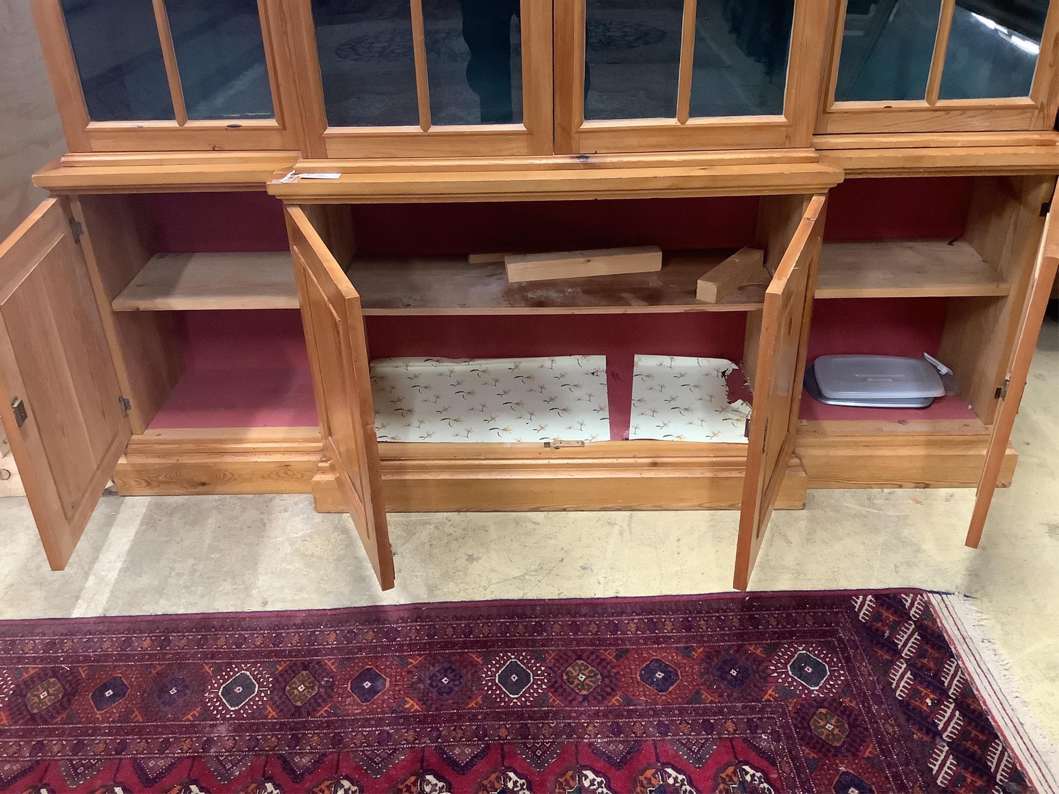 A modern pine breakfront bookcase, width 194cm, depth 44cm, height 207cm. Condition - fair to good